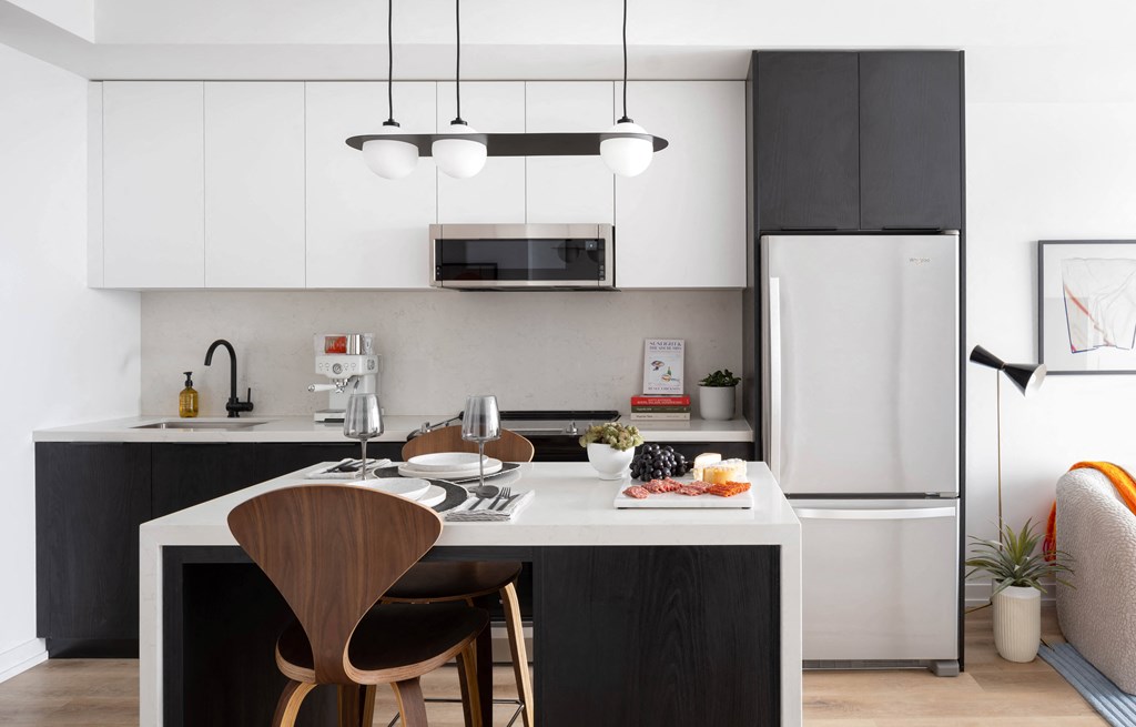 A modern kitchen with a white refrigerator and a wooden chair.