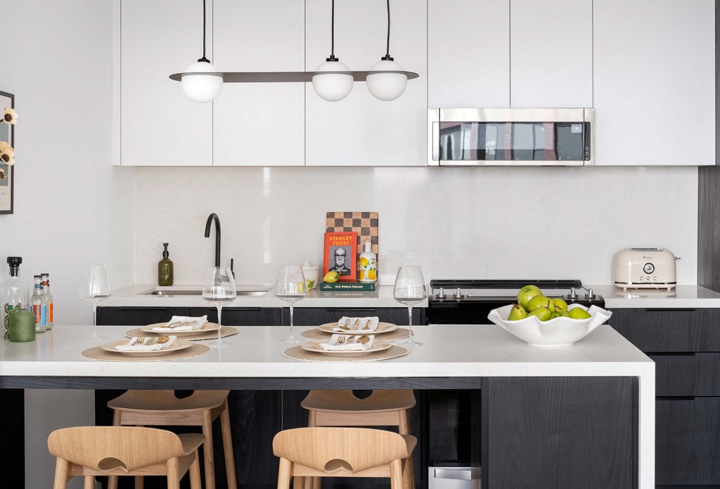 A modern kitchen with white cabinets and a black countertop.