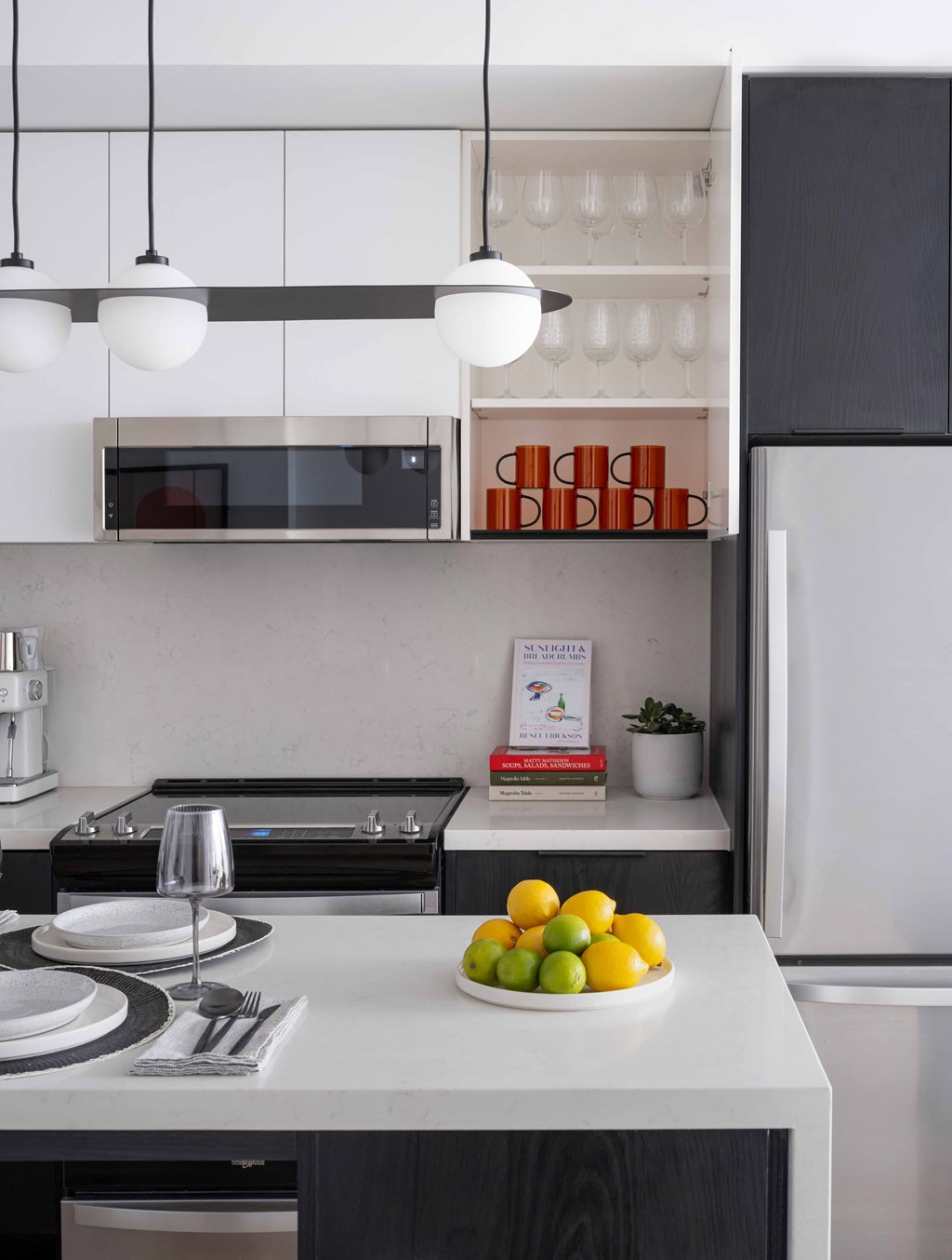 A kitchen with a white counter top and a microwave above it.