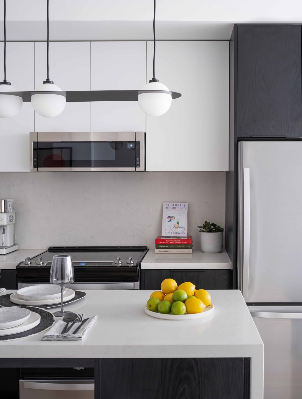 A kitchen with a white countertop and a plate of lemons on it.