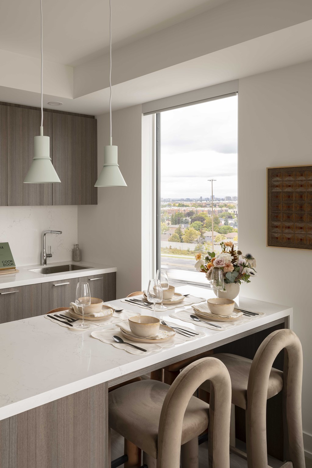 A modern kitchen with a table set for two.