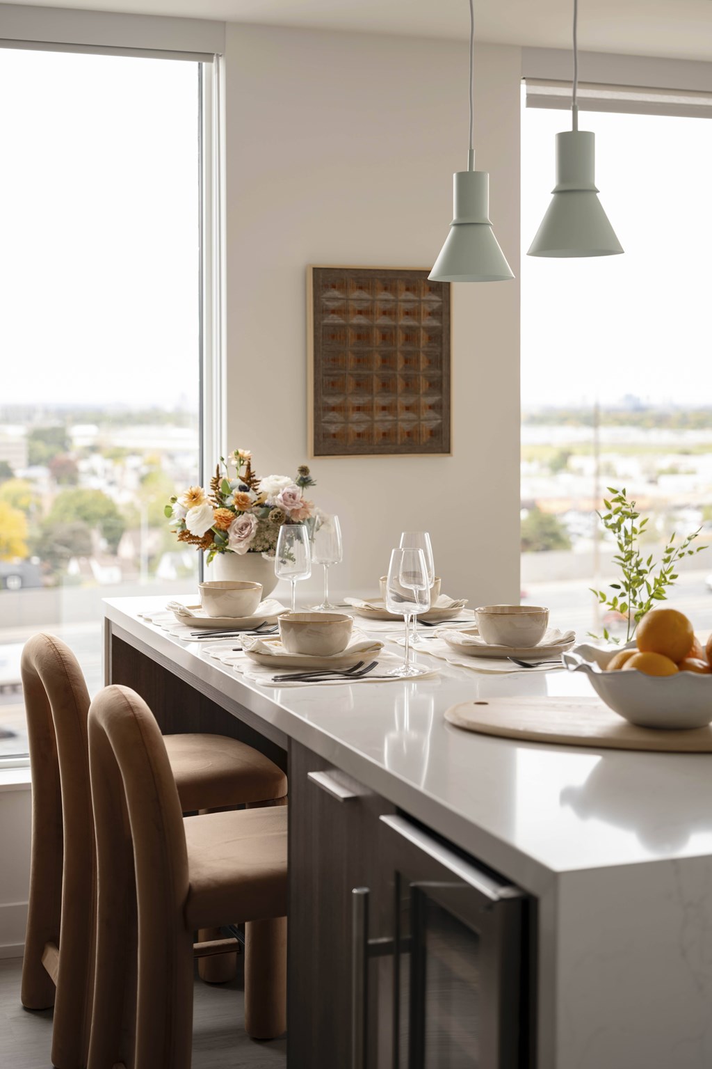 A kitchen with a table set for two with a view of the city.