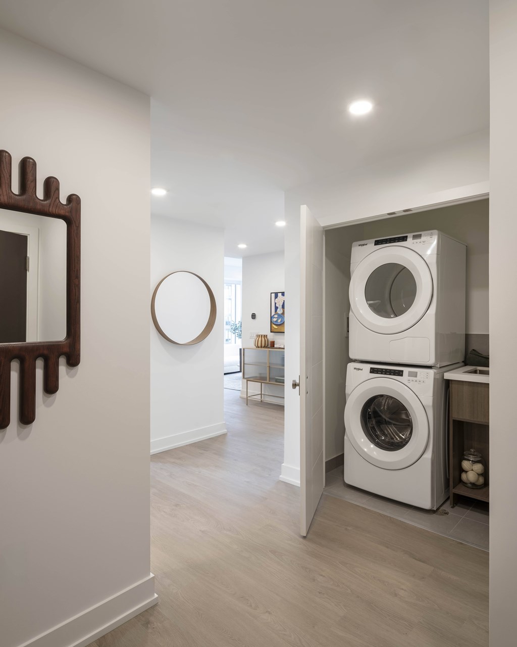 A white washing machine is stacked on top of another in a laundry room.