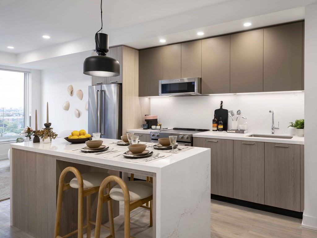 A modern kitchen with a dining table set for two.
