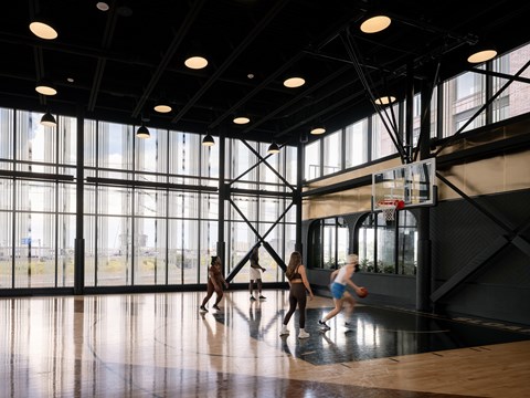 A basketball game is in progress in a spacious gym.