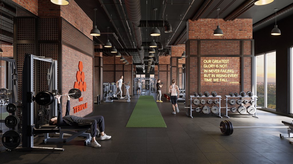 A gym with a brick wall and a green mat in the middle.