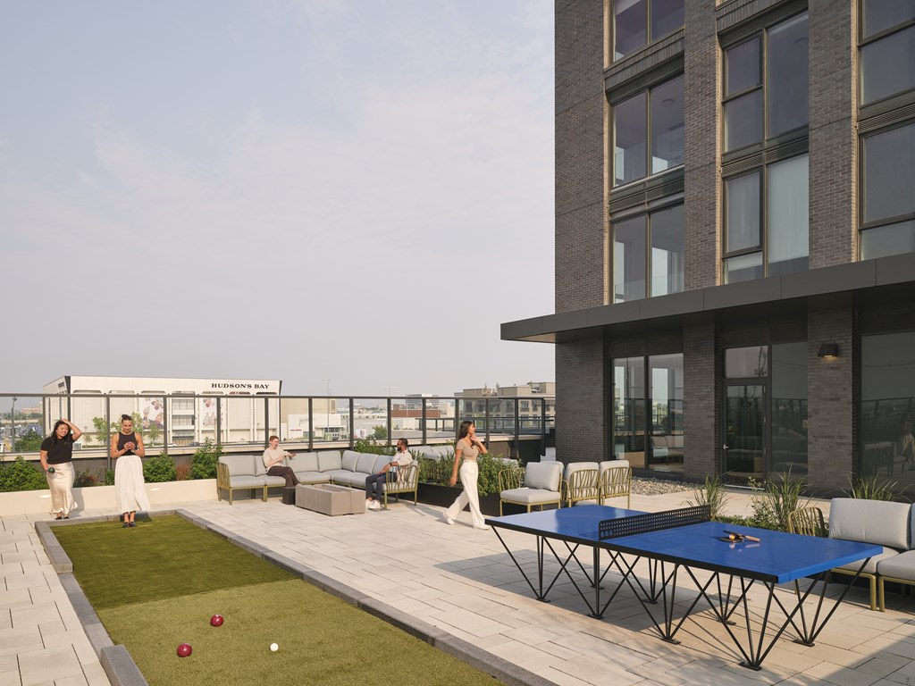 People playing lawn games on a rooftop patio.