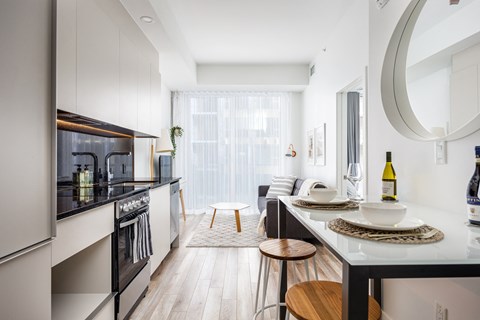 A modern kitchen with a black countertop and stainless steel appliances.