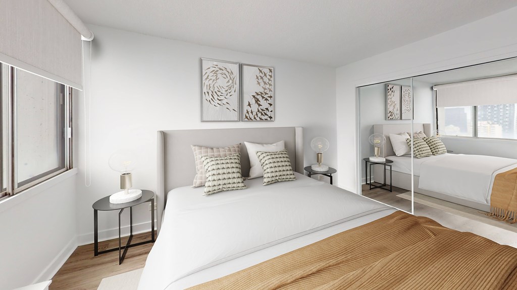 A bedroom with a large bed and a window with blinds.