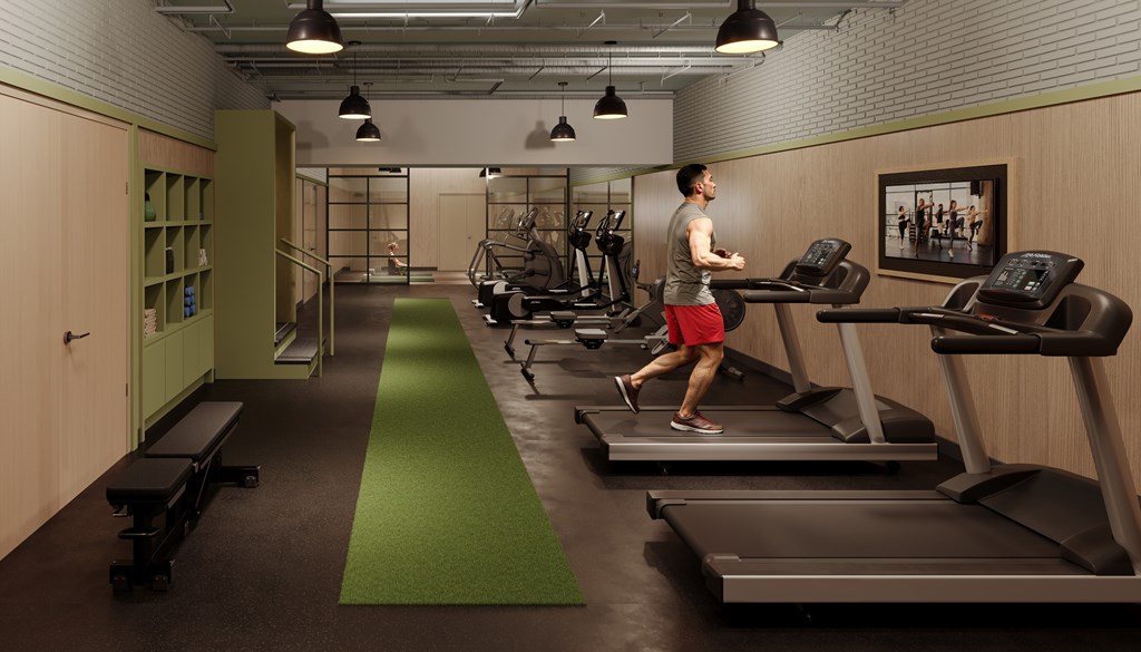 A man is running on a treadmill in a gym.