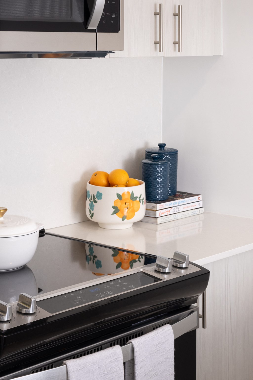 a small kitchen with a bowl of oranges on the counter