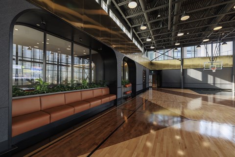 A basketball court with a wooden floor and a basketball hoop.