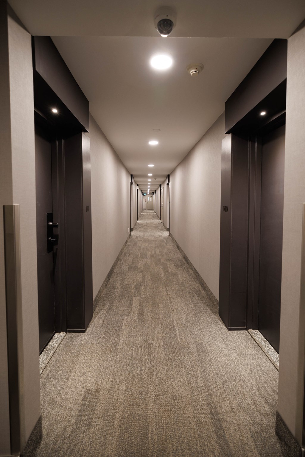 a long corridor with elevators and doors in a building