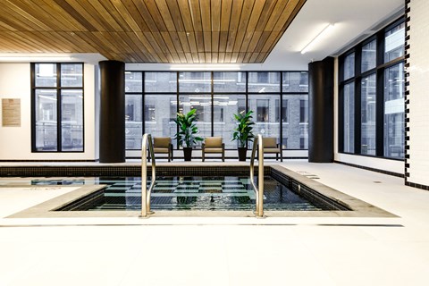 a large room with a pool and chairs in it