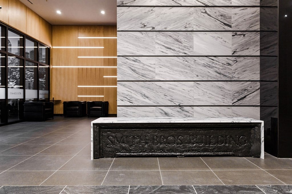 a reception desk in the lobby of a building with marble walls
