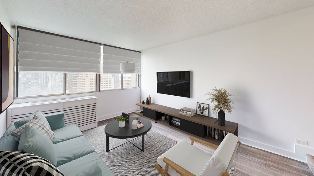 A living room with a couch, a chair, a coffee table, and a television.