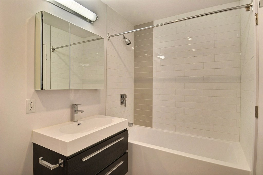 a bathroom with a sink and a shower and a mirror