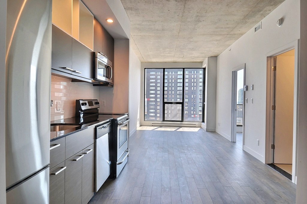 an empty apartment with a kitchen and a door to a balcony