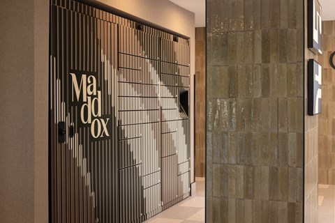 A glass wall with a sign that says Madox.