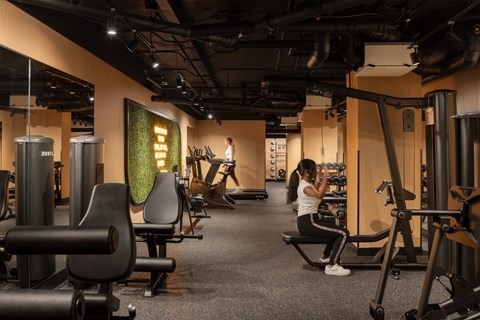 A woman is working out on a machine in a gym.