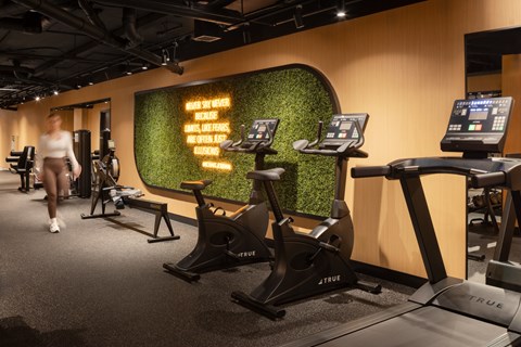 A gym with a green wall and exercise equipment.