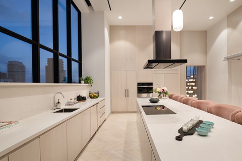 a kitchen with white counter tops and a large window