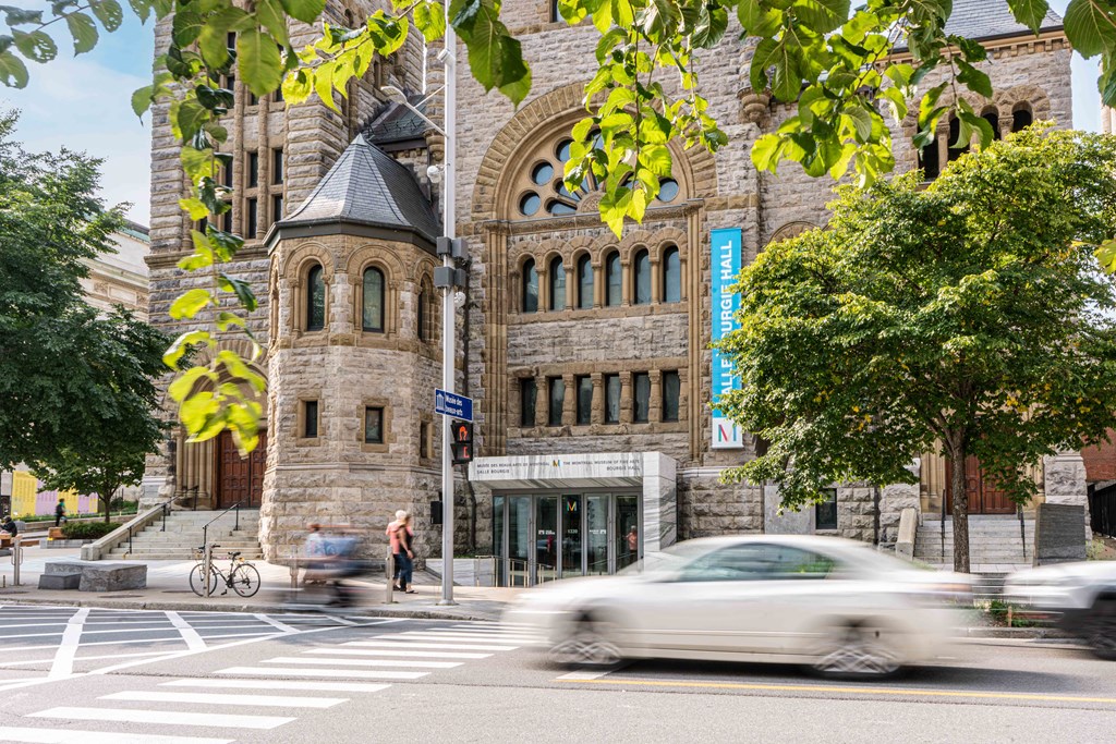a car driving down a street in front of a building
