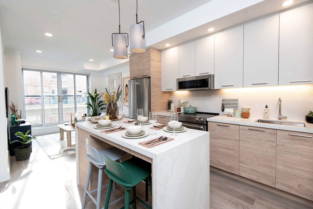 Designer Kitchens with Quartz slab backsplashes and waterfall islands