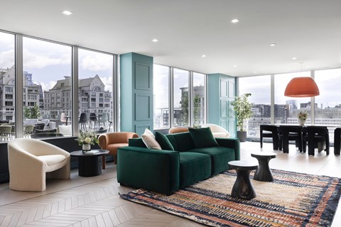 A living room with a green couch and a white chair.