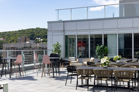 A patio with chairs and tables is set up outside a building.