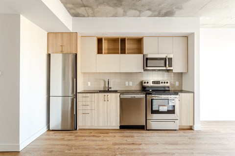 a modern kitchen with stainless steel appliances and white cabinets