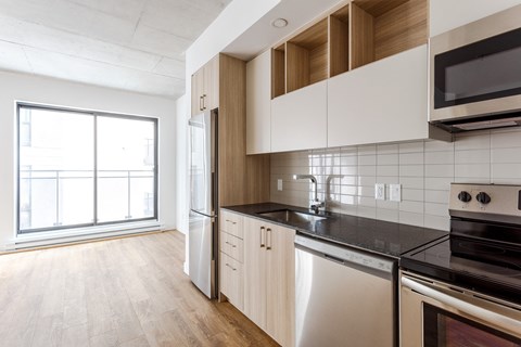 a kitchen with white cabinets and a black counter top