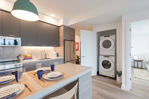 a kitchen with a washer and dryer in it and a table and chairs