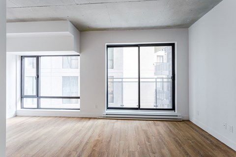 an empty room with wood floors and a large window