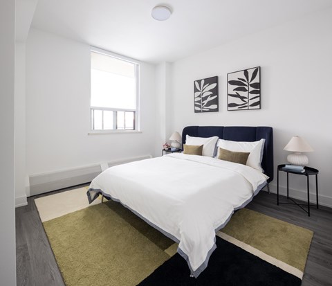 A bedroom with a large bed and a window.