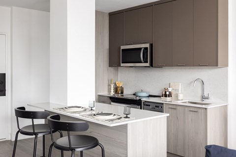 A modern kitchen with a white countertop and brown cabinets.