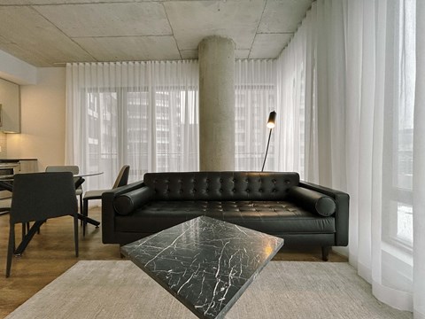 a living room with a black couch and a table