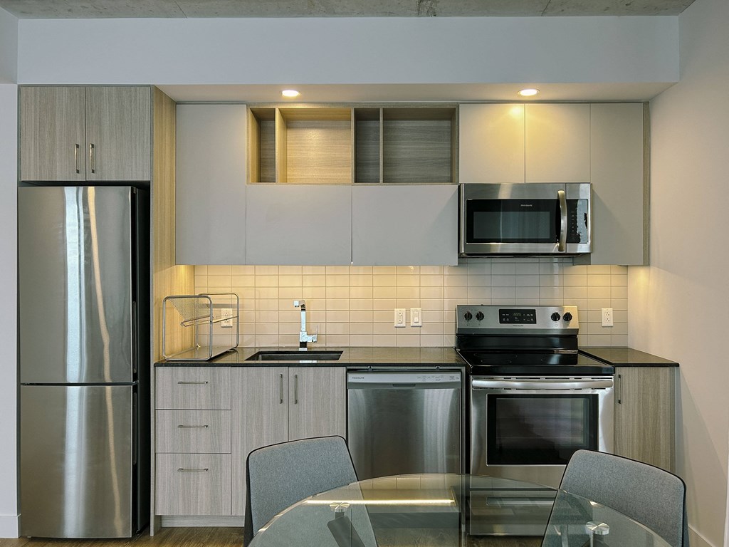 a kitchen with stainless steel appliances and a glass table