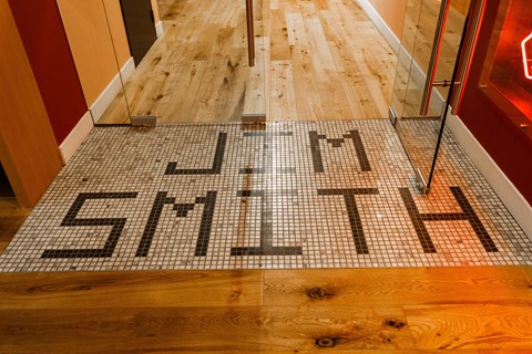 a tile floor with the word gym on it on a wooden floor