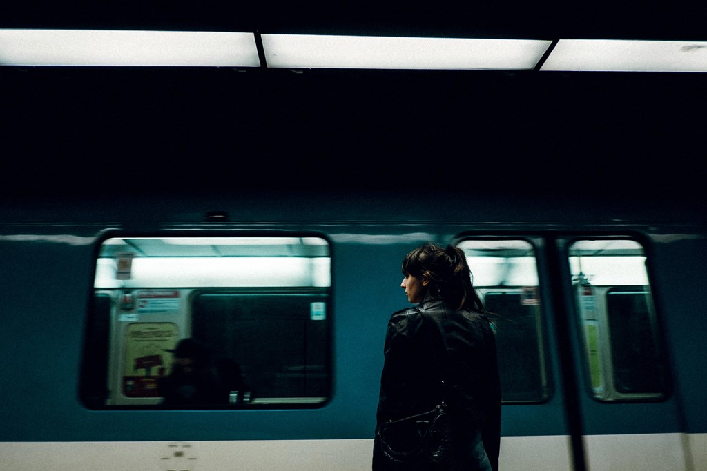 a woman standing in front of a subway train