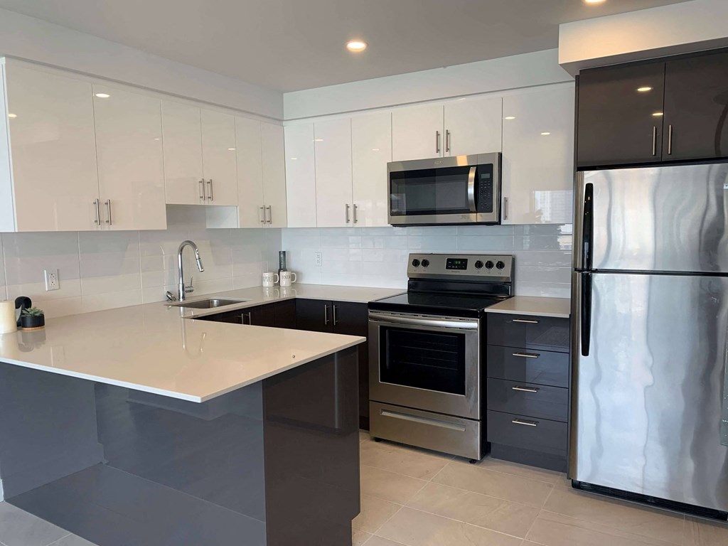 a kitchen with stainless steel appliances and white counter tops