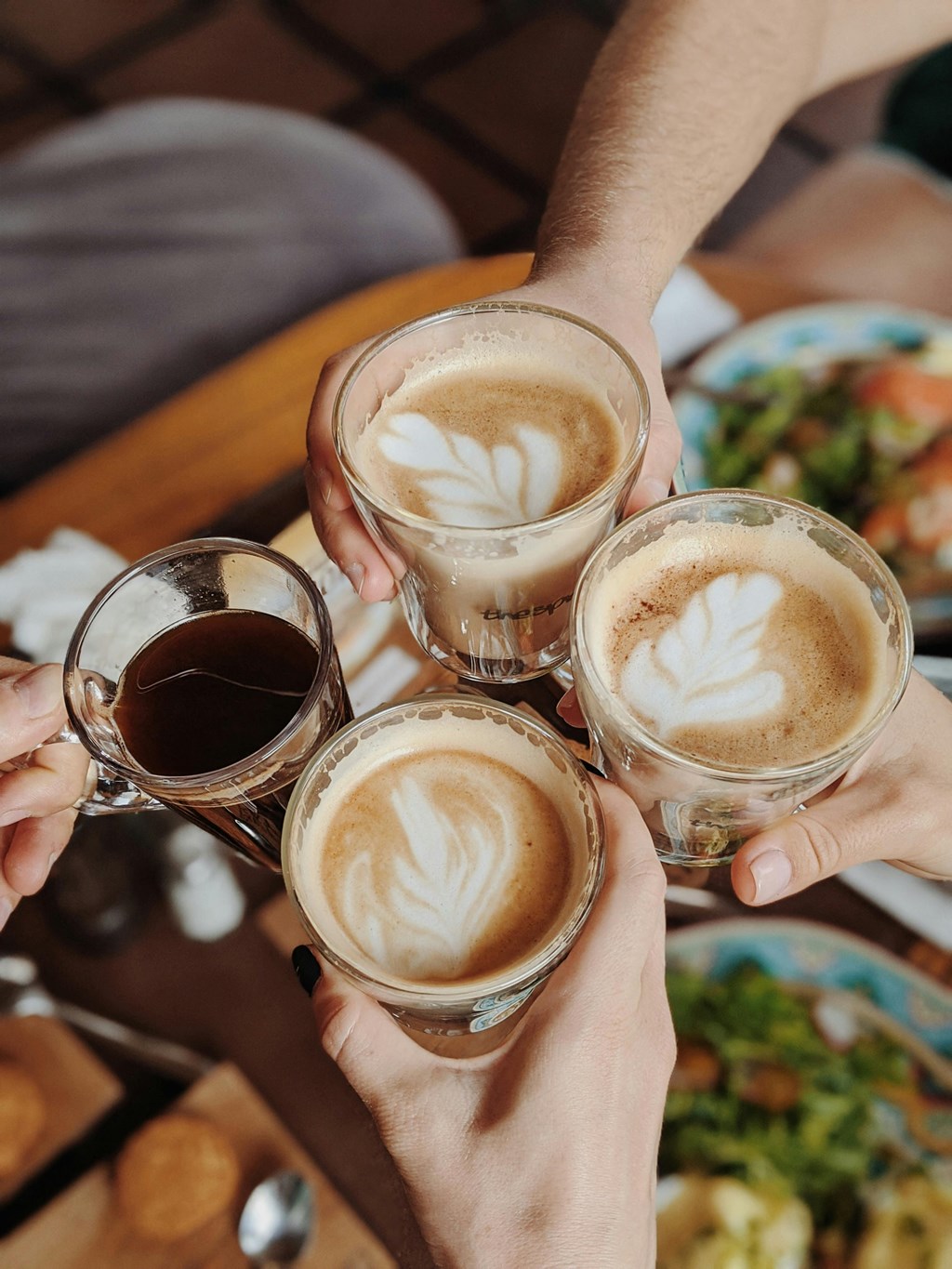 a group of people holding up cups of coffee