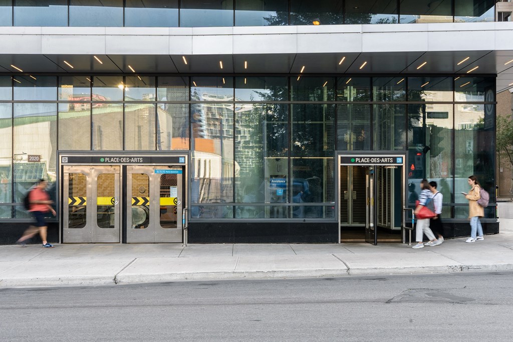 people walking in front of a building with doors