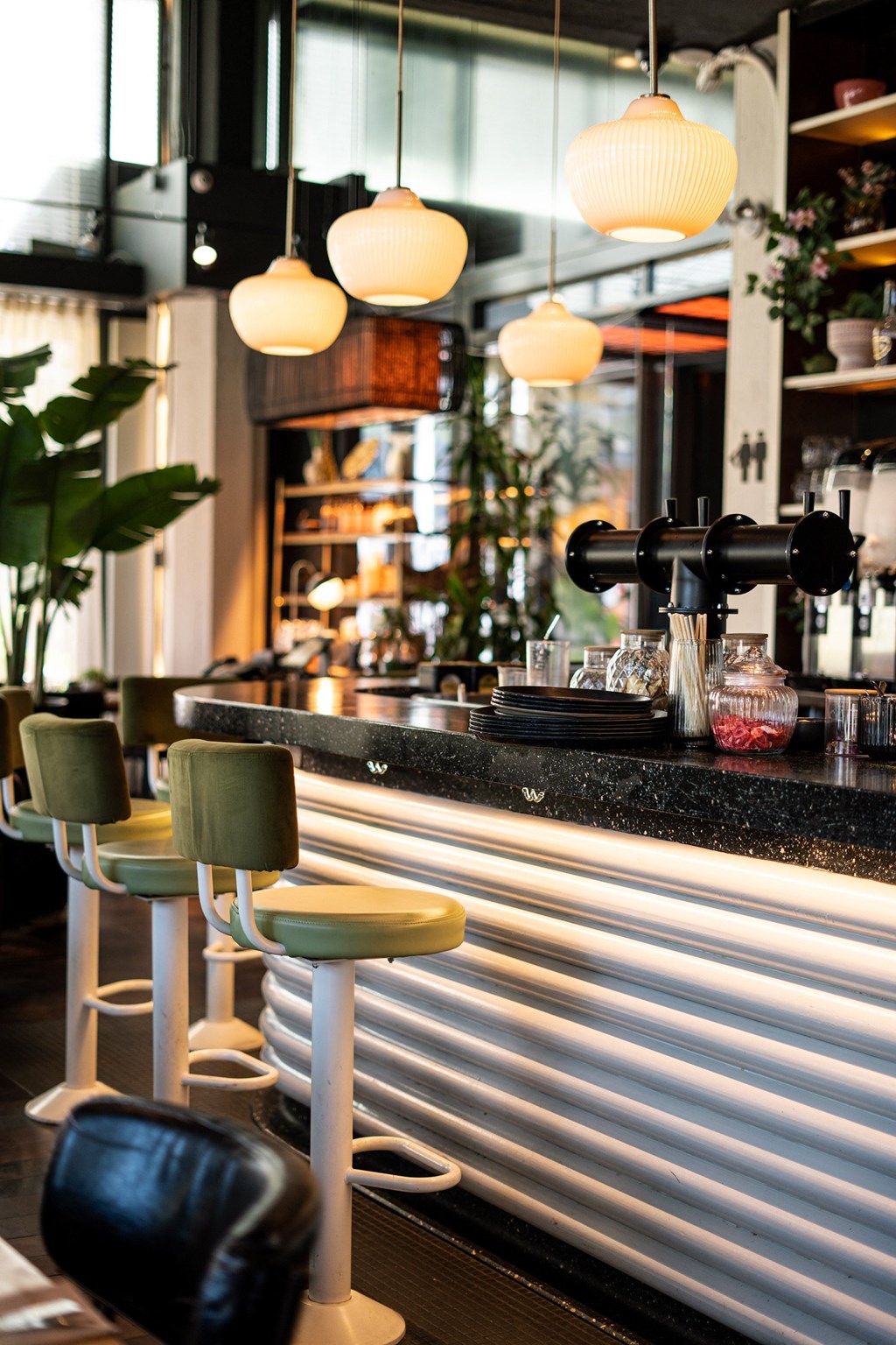 a bar with bar stools and a coffee machine in a restaurant