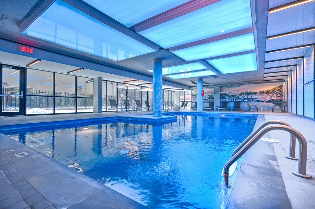 a swimming pool in the middle of a building with glass walls