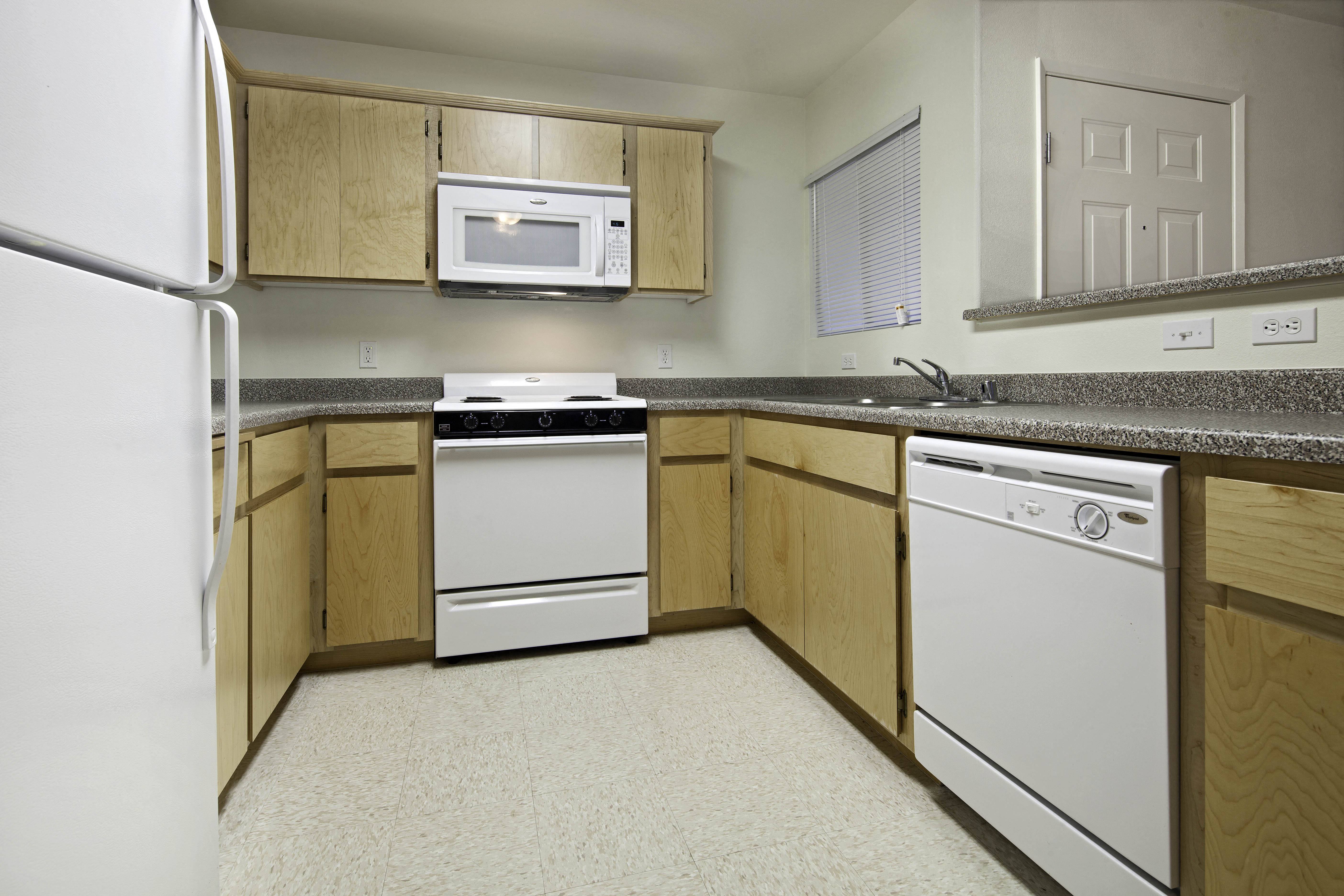 a kitchen with white appliances and wooden cabinets