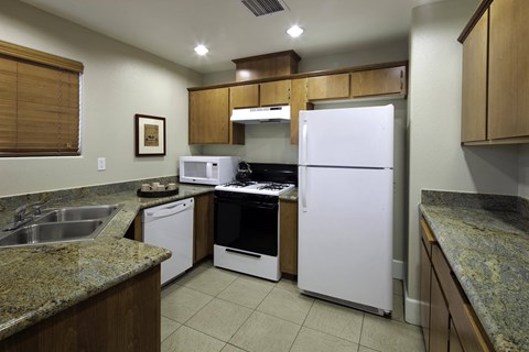 a kitchen with white appliances and granite counter tops