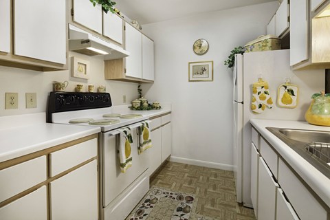 a kitchen with white cabinets and white appliances and a sink