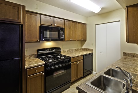 a kitchen with black appliances and granite counter tops