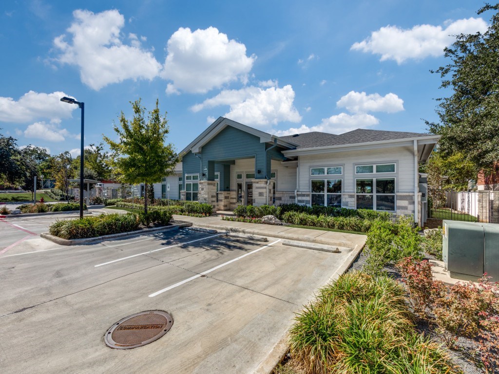 A parking lot in front of a building with a clear blue sky.